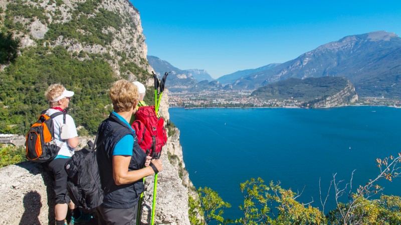 Gr�nn fjellside og bl�tt vann med noen vandrere